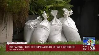 Neighbors stack sandbags, clear storm drains in Lake Worth Beach